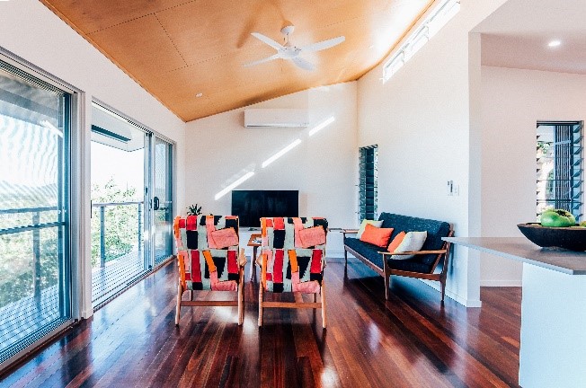 The sliding doors in the living room allow prevailing breezes to cool the house. 