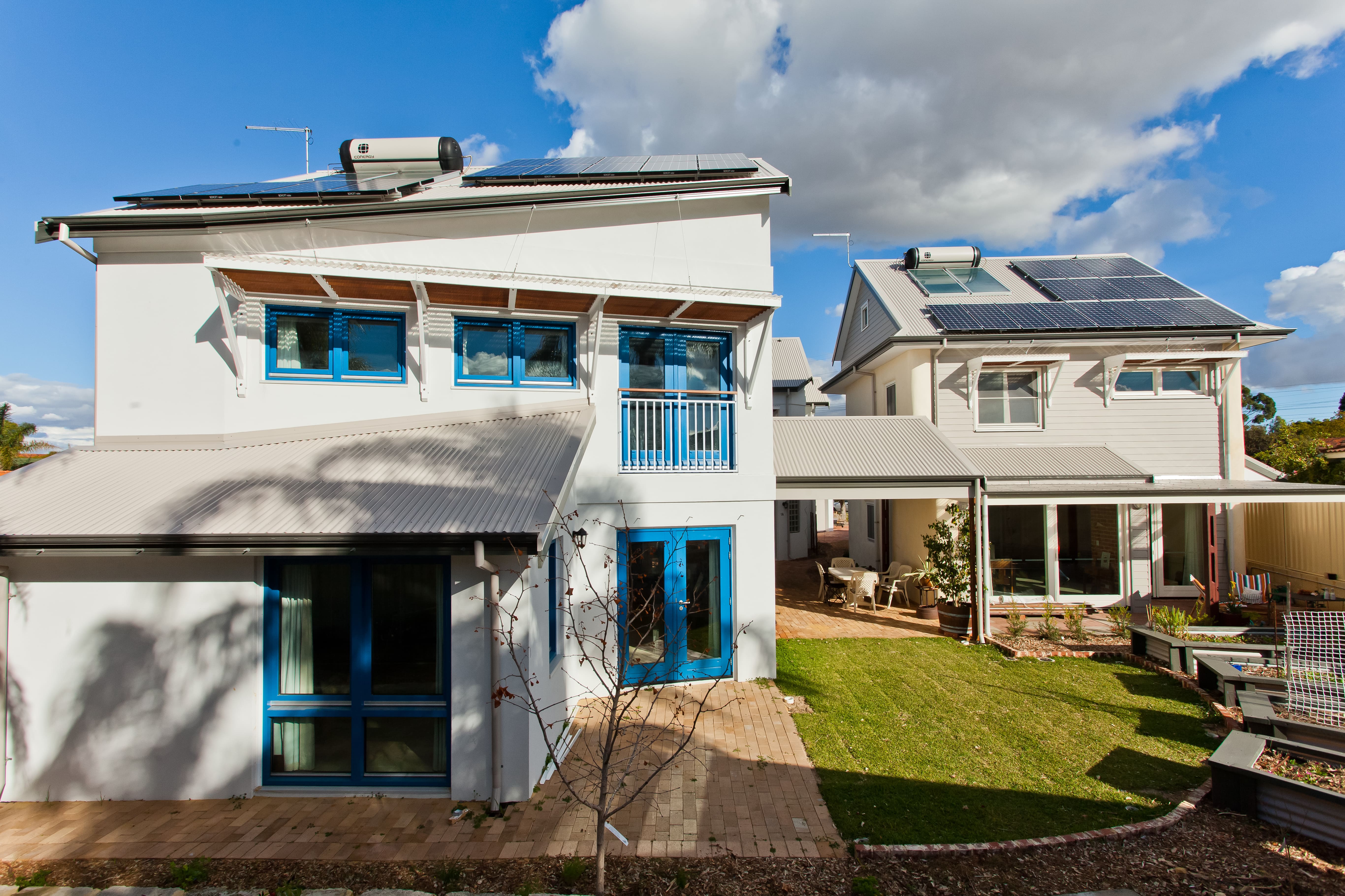 Two townhouses and two apartments have extensive energy saving features, including solar panels and solar hot water systems. The garden between the homes includes lawn as well as raised garden beds. 