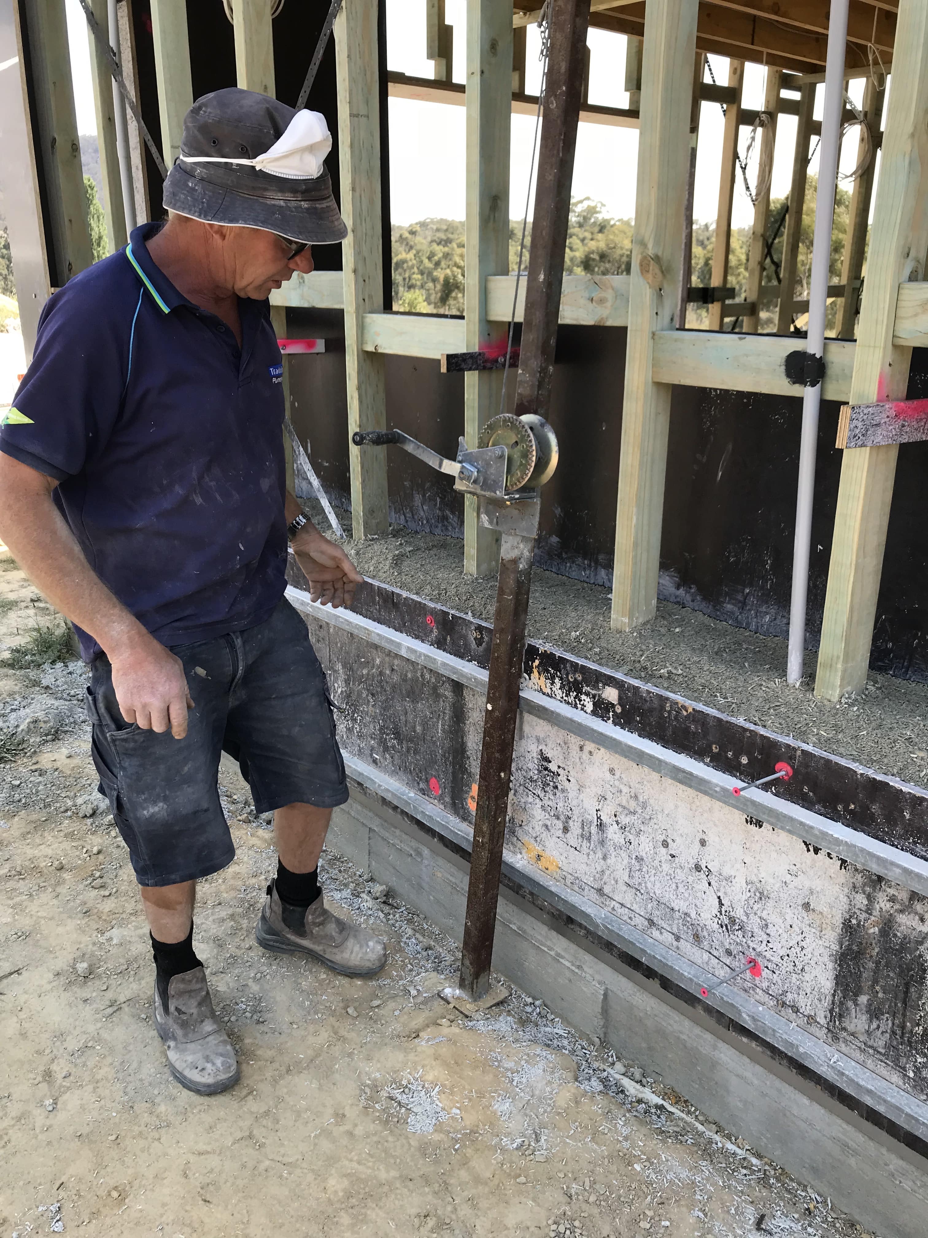 A worker measures the formwork in preparation for the installation of the mixed hemp composite.   